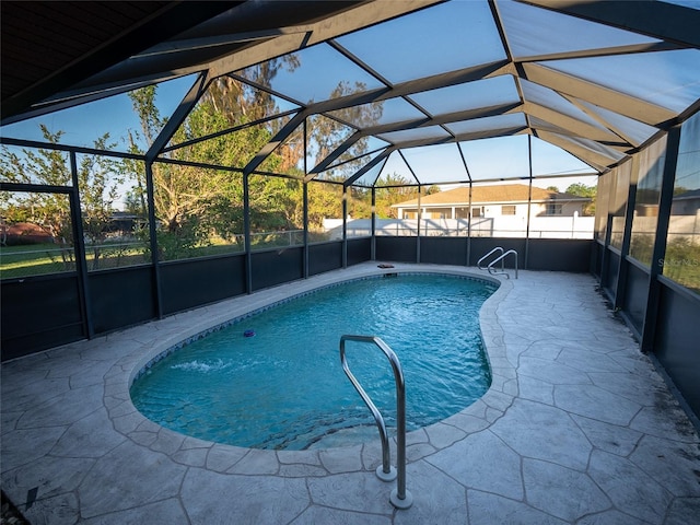 view of swimming pool featuring glass enclosure