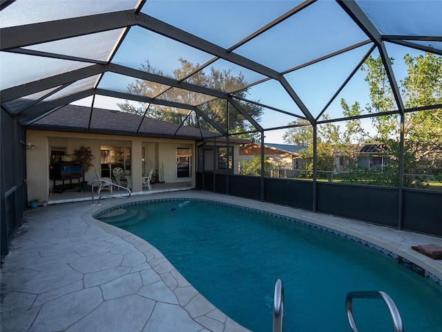 view of swimming pool featuring glass enclosure and a patio