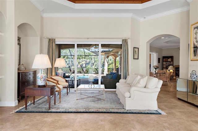 living room featuring a towering ceiling, crown molding, and a tray ceiling