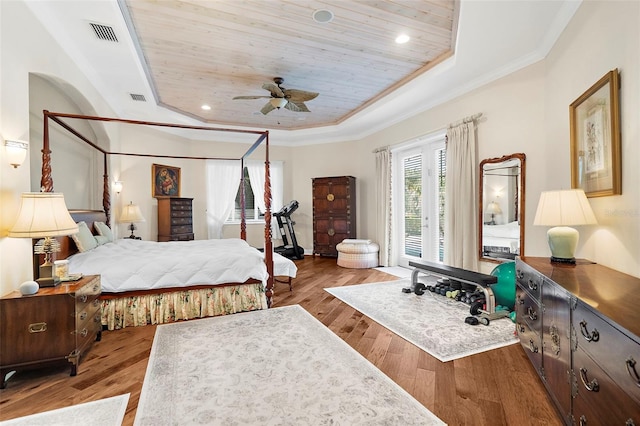 bedroom featuring wooden ceiling, light hardwood / wood-style flooring, ceiling fan, ornamental molding, and a tray ceiling