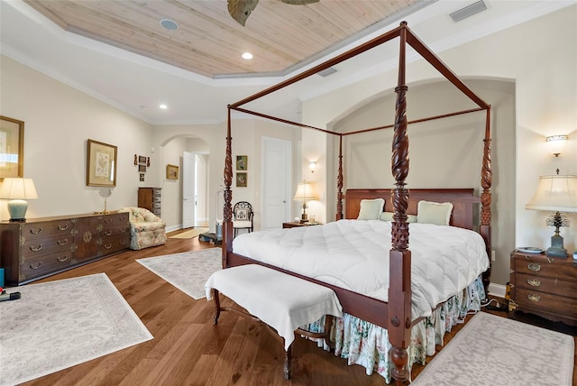 bedroom with hardwood / wood-style flooring, ornamental molding, a tray ceiling, and wooden ceiling