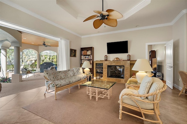 living room featuring a raised ceiling, ornamental molding, and light tile patterned flooring