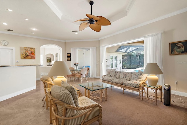 living room with a raised ceiling, ceiling fan, crown molding, and light tile patterned flooring