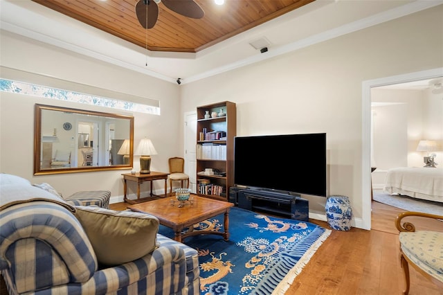 living room featuring ornamental molding, wood ceiling, a raised ceiling, ceiling fan, and hardwood / wood-style flooring