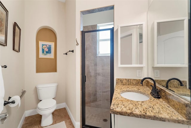 bathroom featuring tile patterned floors, vanity, toilet, and a shower with shower door