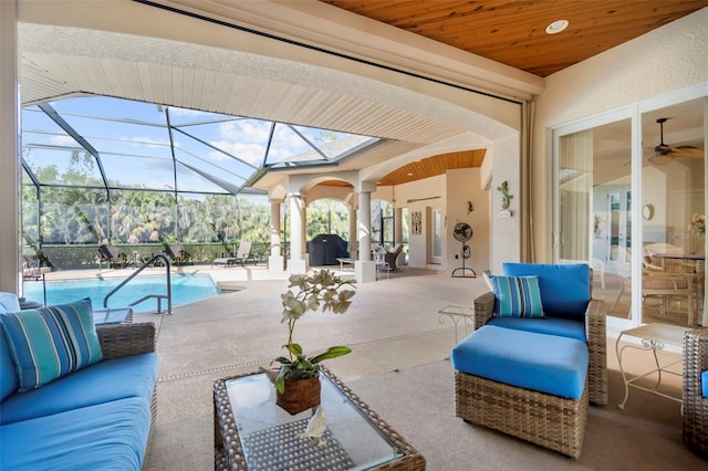 view of patio with outdoor lounge area and glass enclosure