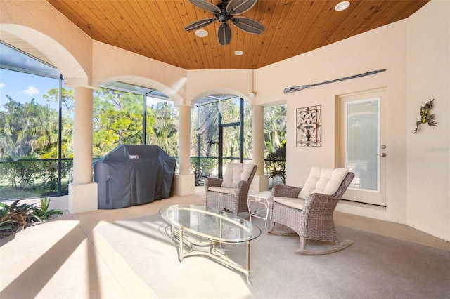 sunroom with ceiling fan and wood ceiling