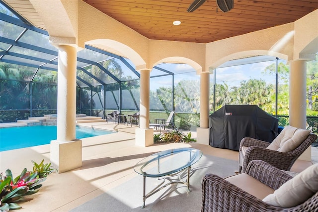 view of patio / terrace with an outdoor living space, glass enclosure, grilling area, and ceiling fan