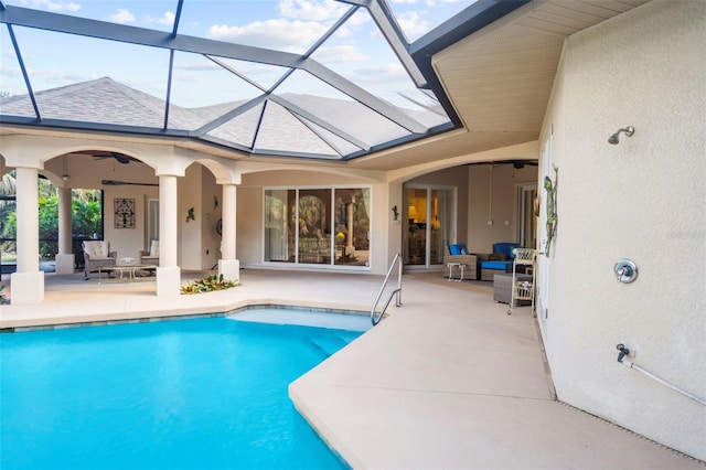 view of pool with outdoor lounge area, ceiling fan, a lanai, and a patio