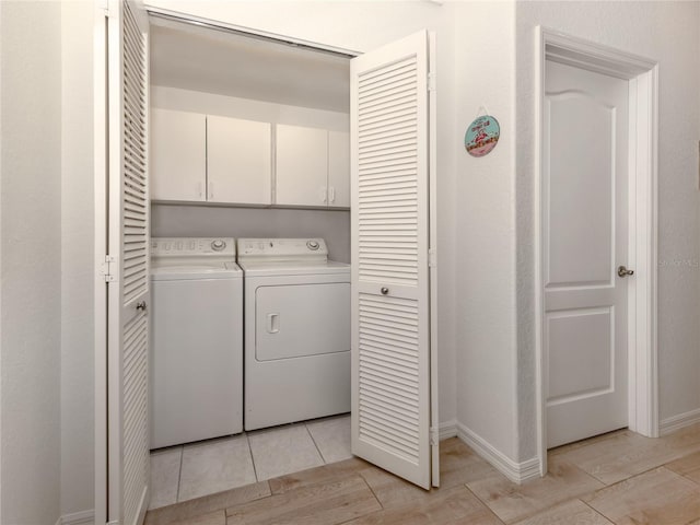 laundry area with washer and clothes dryer and cabinets