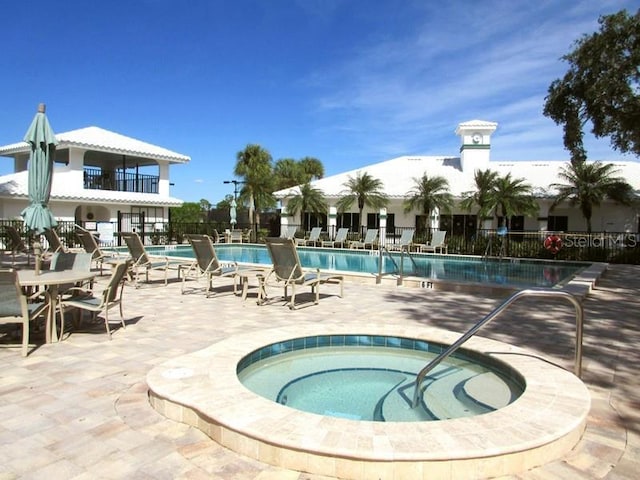 view of swimming pool featuring a patio and a hot tub