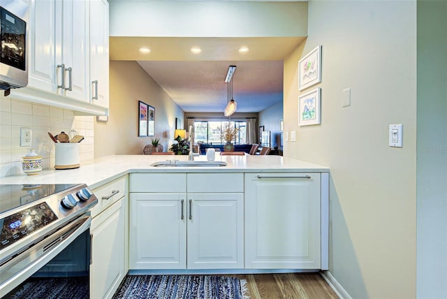 kitchen featuring kitchen peninsula, white cabinetry, dark hardwood / wood-style flooring, and stainless steel appliances