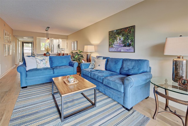 living room featuring a textured ceiling and light hardwood / wood-style floors