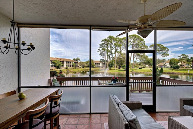 sunroom / solarium featuring ceiling fan and a water view