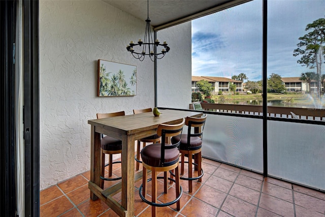 dining room featuring floor to ceiling windows, a water view, and a chandelier