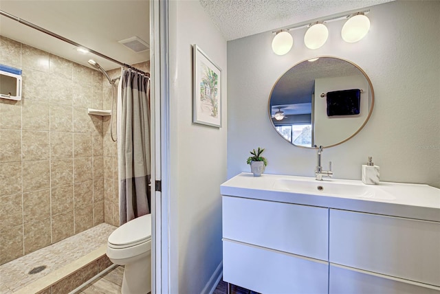 bathroom with walk in shower, vanity, a textured ceiling, hardwood / wood-style flooring, and toilet