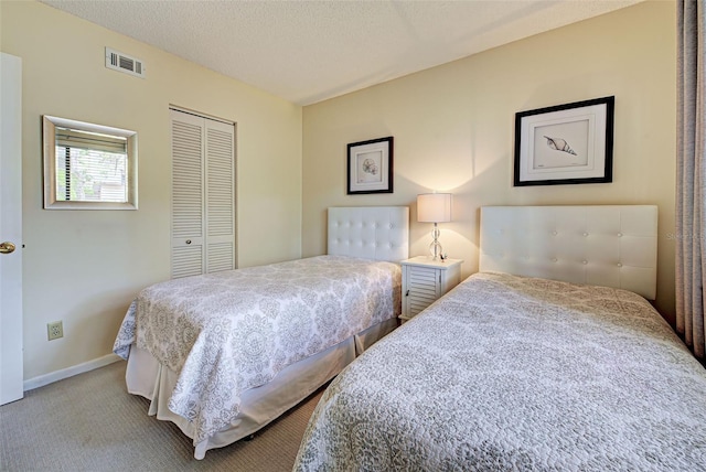 bedroom featuring carpet flooring, a textured ceiling, and a closet