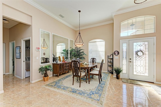 dining room featuring a high ceiling and crown molding