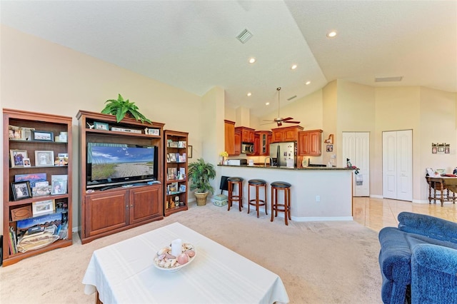 living room with ceiling fan, light carpet, and high vaulted ceiling