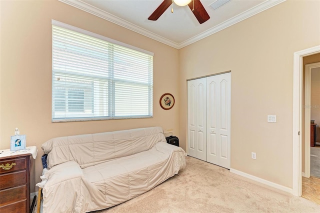 carpeted bedroom featuring ceiling fan, crown molding, and a closet