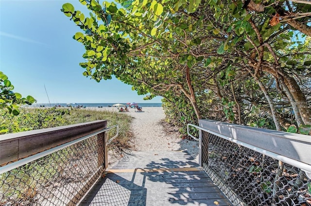 surrounding community with a water view and a view of the beach