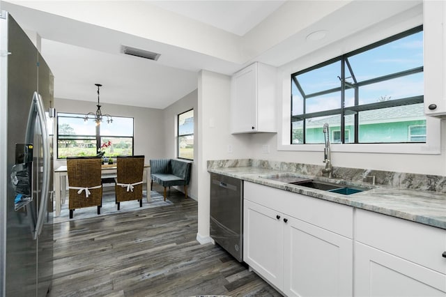 kitchen with hanging light fixtures, white cabinetry, appliances with stainless steel finishes, and sink