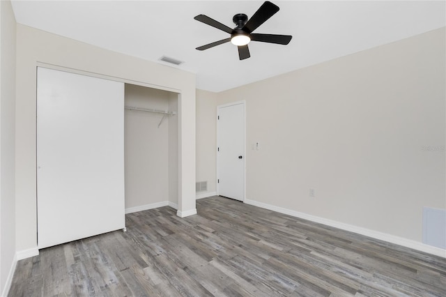 unfurnished bedroom with ceiling fan, light wood-type flooring, and a closet