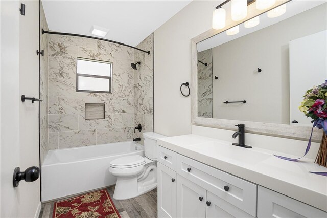 full bathroom featuring hardwood / wood-style flooring, vanity, toilet, and tiled shower / bath combo