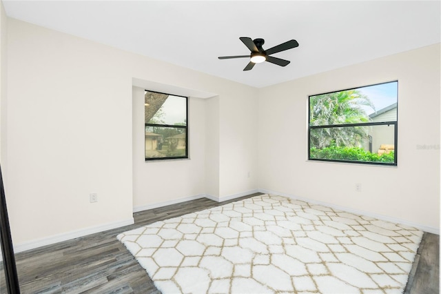 empty room with dark wood-type flooring and ceiling fan