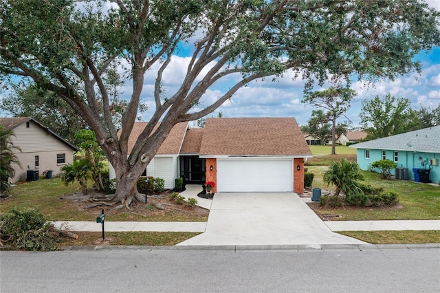 single story home with cooling unit, a garage, and a front lawn