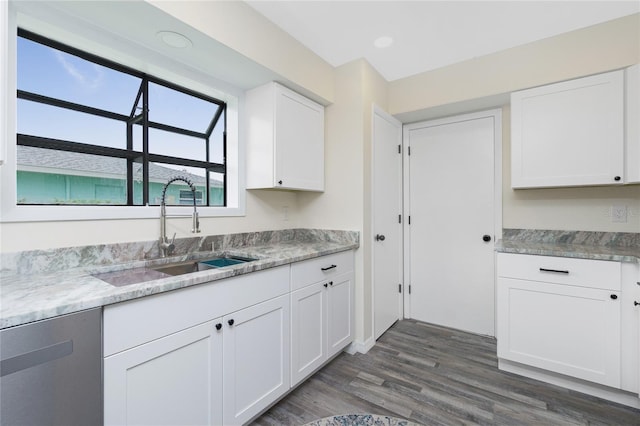 kitchen with sink, light stone counters, dark hardwood / wood-style floors, dishwasher, and white cabinets