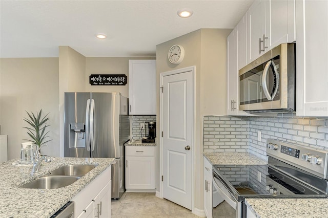 kitchen featuring light stone countertops, sink, white cabinets, and stainless steel appliances