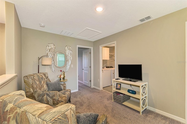 living room featuring washer and dryer, carpet floors, and a textured ceiling