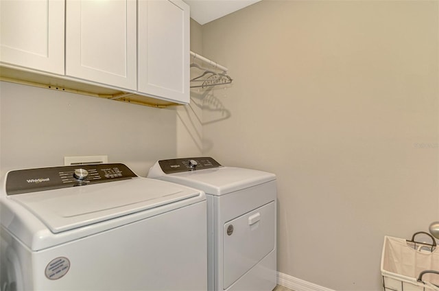 washroom featuring cabinets and washing machine and clothes dryer