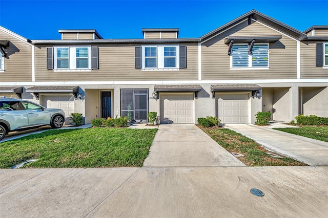 view of property featuring a front lawn and a garage