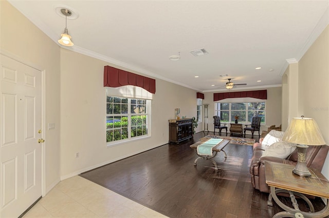 living room featuring light hardwood / wood-style flooring, ceiling fan, and crown molding