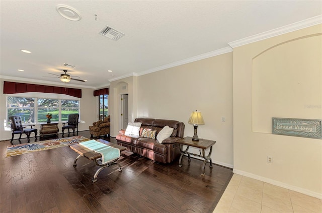 living room featuring ceiling fan, light hardwood / wood-style floors, and ornamental molding