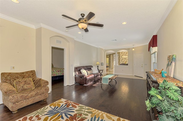 living room with ceiling fan, ornamental molding, dark wood-type flooring, and a wealth of natural light