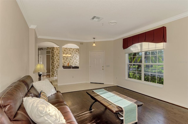 living room featuring hardwood / wood-style flooring, ornate columns, and ornamental molding