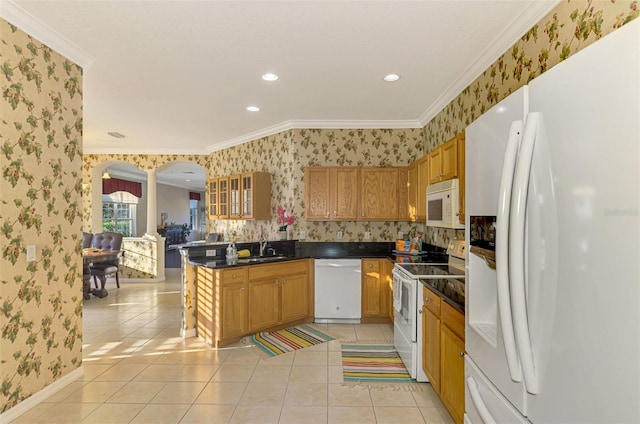 kitchen featuring ornate columns, crown molding, light tile patterned floors, and white appliances