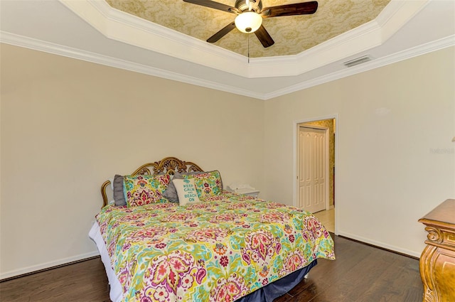 bedroom featuring ceiling fan, dark hardwood / wood-style floors, a tray ceiling, a closet, and ornamental molding