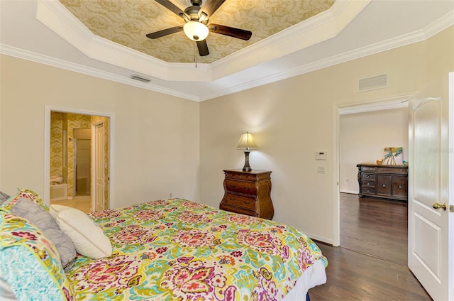 bedroom featuring ceiling fan, dark hardwood / wood-style floors, ornamental molding, and connected bathroom