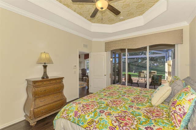 bedroom with ceiling fan, a raised ceiling, dark hardwood / wood-style flooring, access to outside, and ornamental molding