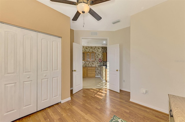 unfurnished bedroom featuring ceiling fan, a closet, and light hardwood / wood-style floors