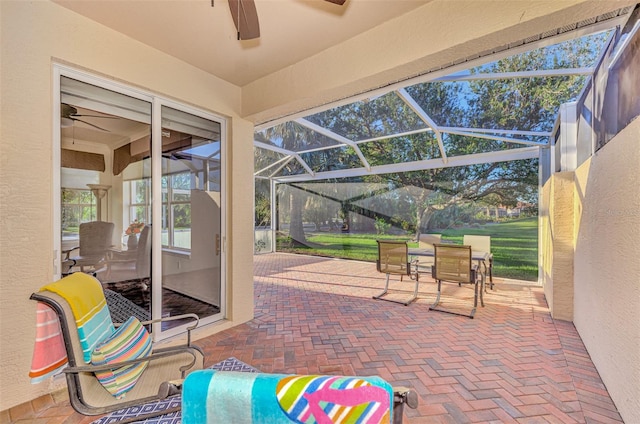 view of patio featuring ceiling fan and a lanai