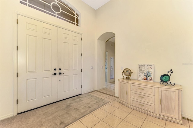 tiled foyer with a towering ceiling