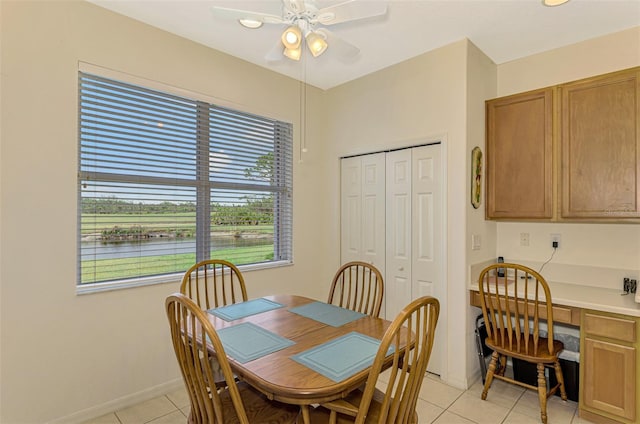 tiled dining area with plenty of natural light and ceiling fan