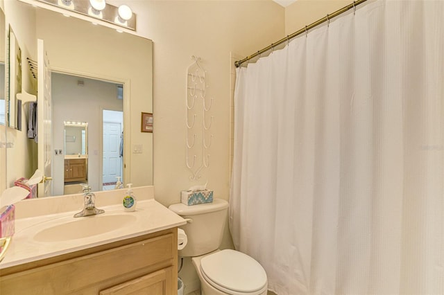 bathroom featuring vanity, toilet, and curtained shower