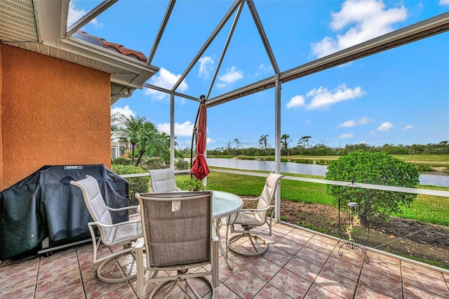 view of patio / terrace with a water view, grilling area, and a lanai