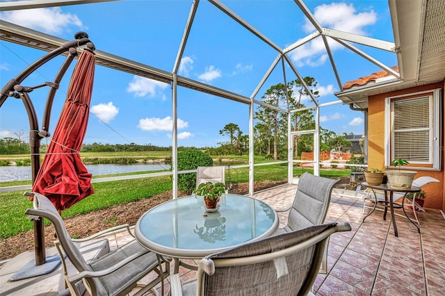 view of patio featuring a water view and a lanai